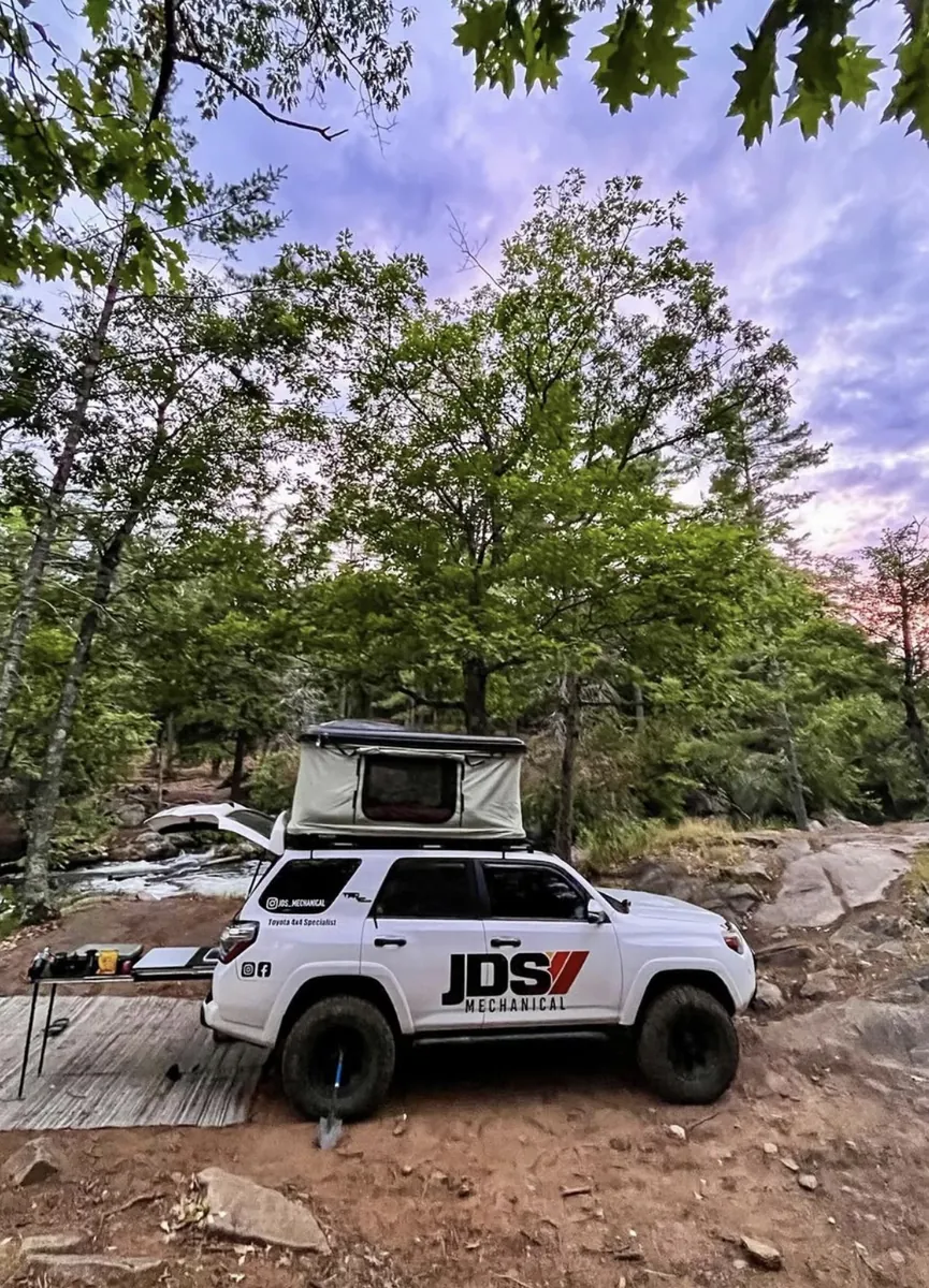 JDS 4Runner camp setup at dusk with rooftop tent and camp table.